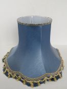A large blue and cream silken lamp shade.