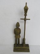 A brass doorstop in the form of a policeman with Victorian lamp post over,
