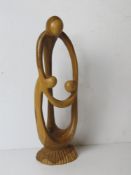 A carved wooden mother and children contemporary sculpture.