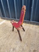 A carved wooden three legged high backed stool having leatherette seat.