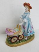 A Dresden Porcelain figurine of a lady pushing a pram, arm a/f, hand painted and gilded throughout,
