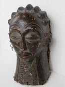 A large hand carved wooden wall mask of a female,