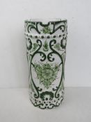 A hand painted ceramic umbrella stand in white ground with green floral decoration upon,