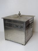 A chromed square shaped log or coal bin.