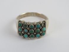 A handmade Native American turquoise ring, one stone deficient, unmarked white metal,