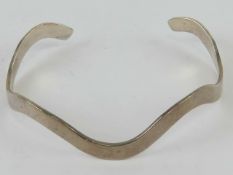 A hallmarked silver bangle in wave design, hallmarked 925, slightly adjustable size, 12.5g.