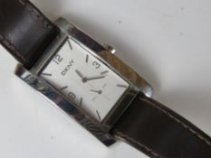 A ladies DKNY wrist watch having square shaped stainless steel head numbered 340001 on brown