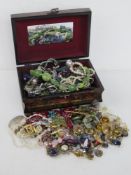 A contemporary jewellery box containing a quantity of assorted costume jewellery.