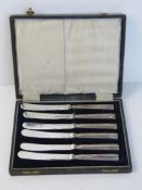 A set of six hallmarked silver handled butter knives, one handle loose, within fitted case.