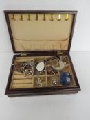 A contemporary wooden jewellery box containing a small quantity of costume jewellery.