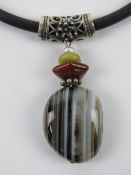 An agate pendant with white metal mount on black rubberised necklace having 925 silver clasp.