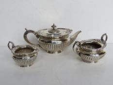 A hallmarked silver tea service comprising teapot, milk and sugar bowl,