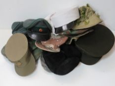 A quantity of assorted military caps and hats, includes a Kepi cap, US Army officers cap,