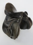 A black leather saddle by Berkeley inc stirrups, size 18 3/4