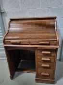 An early 20th century oak roll top desk ' The Lebus Desk' having four graduated drawers with slide