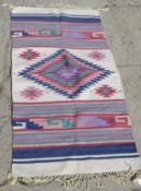 A contemporary woven 'garden rug' in multi coloured Aztec pattern, measuring approx 143 x 74cm.