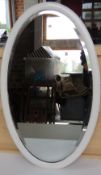 An oval wall hanging mirror in white painted wooden frame, overall 73 x 45cm.