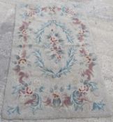 A vintage woollen rug in floral pattern on cream ground, for cleaning. Measuring approx 150 x 88cm.