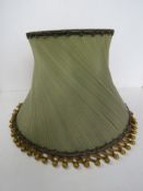 A large green standard lampshade having gold silken bead decoration, approx 53cm dia.