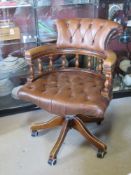A brown Chesterfield type captain's chair in need of light refurbishment. (castor deficient).