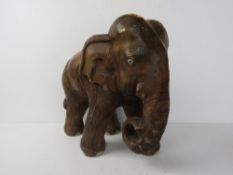 A carved wooden sculpture of an elephant standing 34cm high.