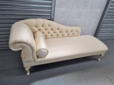 A smartly upholstered chaise longue in cream ground with cream painted cabriole legs,