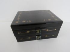 A contemporary black glass jewellery box having gold floral decoration upon, slightly a/f to back.