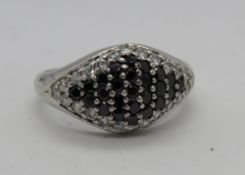 A silver cocktail ring encrusted with white and black cz stones, stamped 925, size S.