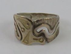 A silver ring having carved Aztec pattern upon, marks indistinct, size O.