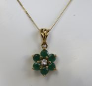 A 9ct gold floral pendant having diamond centre and emerald petals, on fine 9ct gold chain.