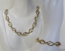 A 9ct gold suite of jewellery comprising necklace and bracelet, each having oval wave panel design,