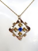 An Edwardian 9ct gold pendant having floral design with central blue paste stone, stamped 9ct,