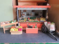 A dolls house greengrocer's market stall with wares, barrow of sacks, etc.