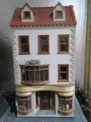 A dolls house having well stocked butchers shop to the ground floor with home over three upper