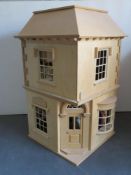 A two storey dolls house opening to reveal a toy shop with vast array of toys within,