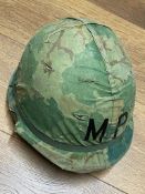 A US M1 MP helmet with liner and foliage