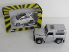 A die cast scale model Fiat 500 by Cararama 1:43 scale together with a Landrover Defender in silver.