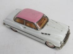 A 1/18 scale model car in pink and white, metal construction.