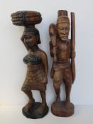 Two large wooden African carvings of a man and woman each standing approx 62cm high.