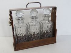 A silver plated Tantalus housing trio of cut glass decanters, key deficient.