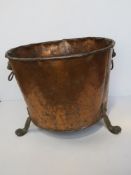 A copper and brass coal or log bin having lions head handles, raised over lions paw feet, 45.