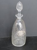 A cut glass decanter having etched floral design upon with silver plated whisky label,