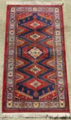 A woollen rug in red and blue ground having geometric pattern, approx 130 x 170cm.