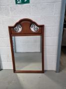 A contemporary wall mirror with 'ironwork' detail to top.