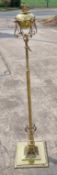 A large brass standard oil lamp having square shaped base with cast iron weight,