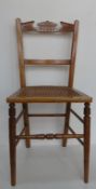 A single cane seated bedroom chair having carved back.