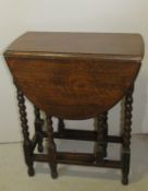 An oak barley twist fold over occasional table measuring approx 90 x 60cm (extended), 72cm high.