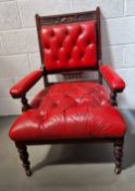 A Victorian Gothic Revival library chair upholstered in red leather and having floral carving to