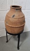 A decorative terracotta plant pot on wrought iron stand, approx 84cm high.
