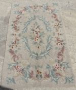 A vintage woollen rug in floral pattern on cream ground, for cleaning. Measuring approx 150 x 88cm.